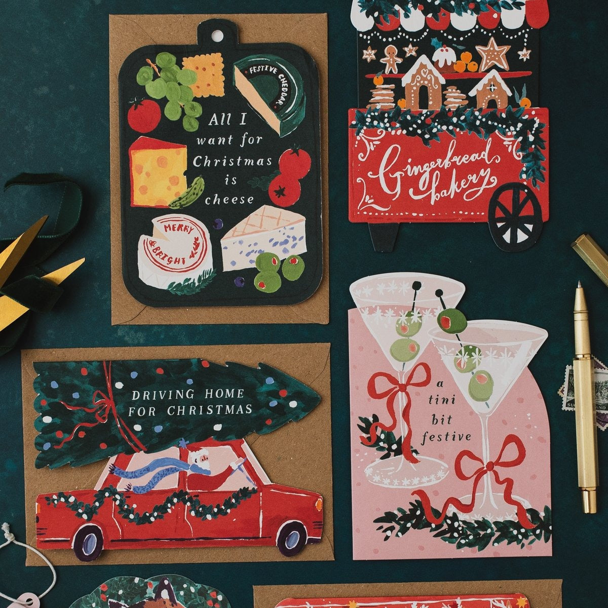 Gingerbread bakery cart Christmas card on a dark teal background with cheeseboard, martini and Driving Home for Christmas shaped cards
