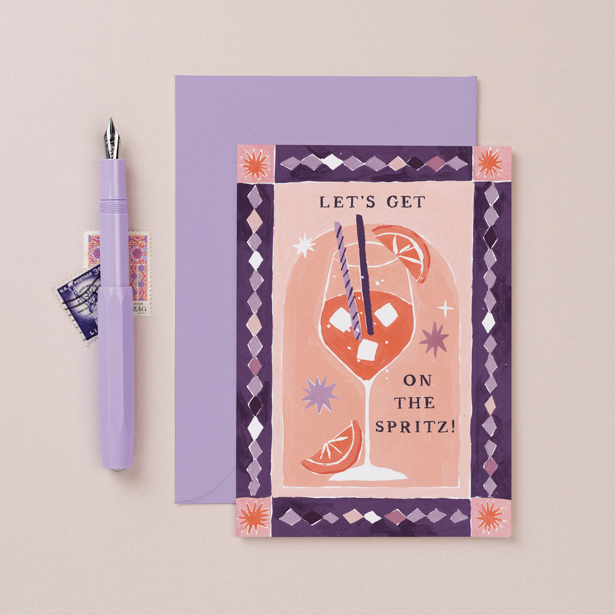 Greeting card with a spritz-themed design and a pen on a beige background
