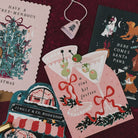 Here Comes Santa Paws dogs Christmas card on a deep red background with Tree-mendous, martini and Jingle & Co bookshop Christmas cards