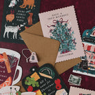 Here Comes Santa Paws dogs Christmas card on a deep red background with Tree-mendous, mulled wine and cheeseboard Christmas cards