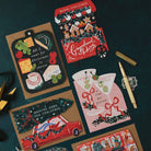 Cheeseboard shaped Christmas card on a dark teal background with gingerbread cart, martini and Driving Home for Christmas cards