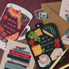 Mulled wine & Christmas time shaped card on a deep red background with cheeseboard and Bookish Christmas cards