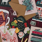 Mulled wine shaped Christmas card on a deep red background with martini, cheeseboard and Bookish Christmas cards