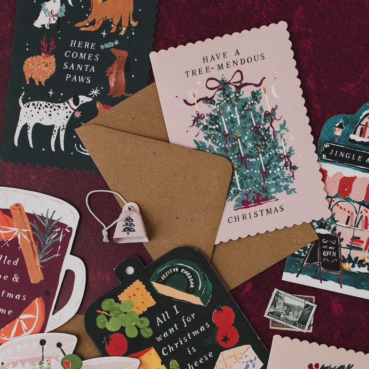 Have a Tree-mendous Christmas card on a deep red background with Santa Paws, mulled wine and cheeseboard Christmas cards