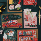 Driving Home for Christmas car shaped card on a dark teal background with martini, cheeseboard and gingerbread cart Christmas cards