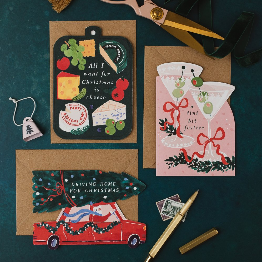 Tini Bit Festive martini, cheeseboard and Driving Home for Christmas shaped cards with kraft envelopes on a dark teal background
