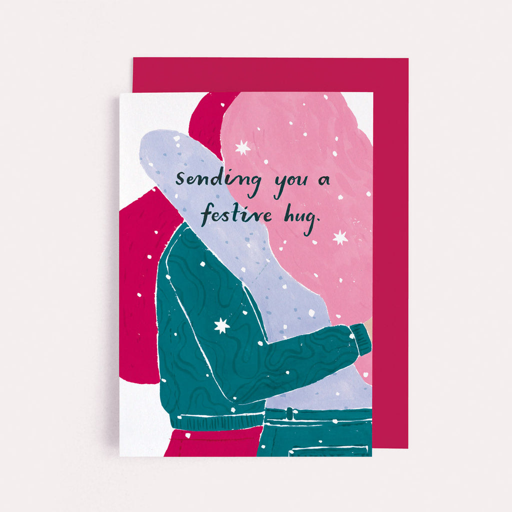 Sending you a festive hug, girls hugging on a Christmas card from the fun and funny Christmas thinking of you card collection at Sister Paper Co.