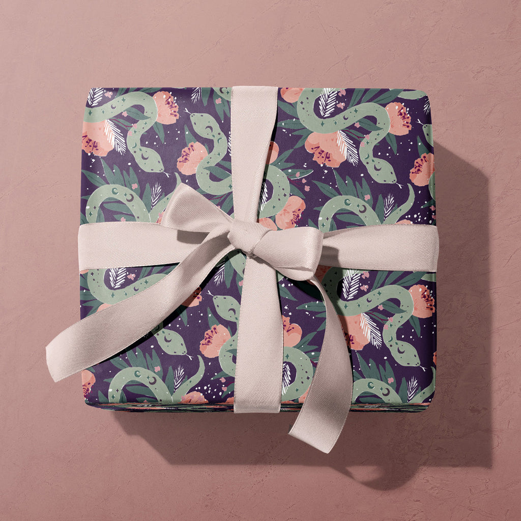 A mystical, floral snake print on wrapping paper from the female birthday wrapping paper collection at Sister Paper Co.